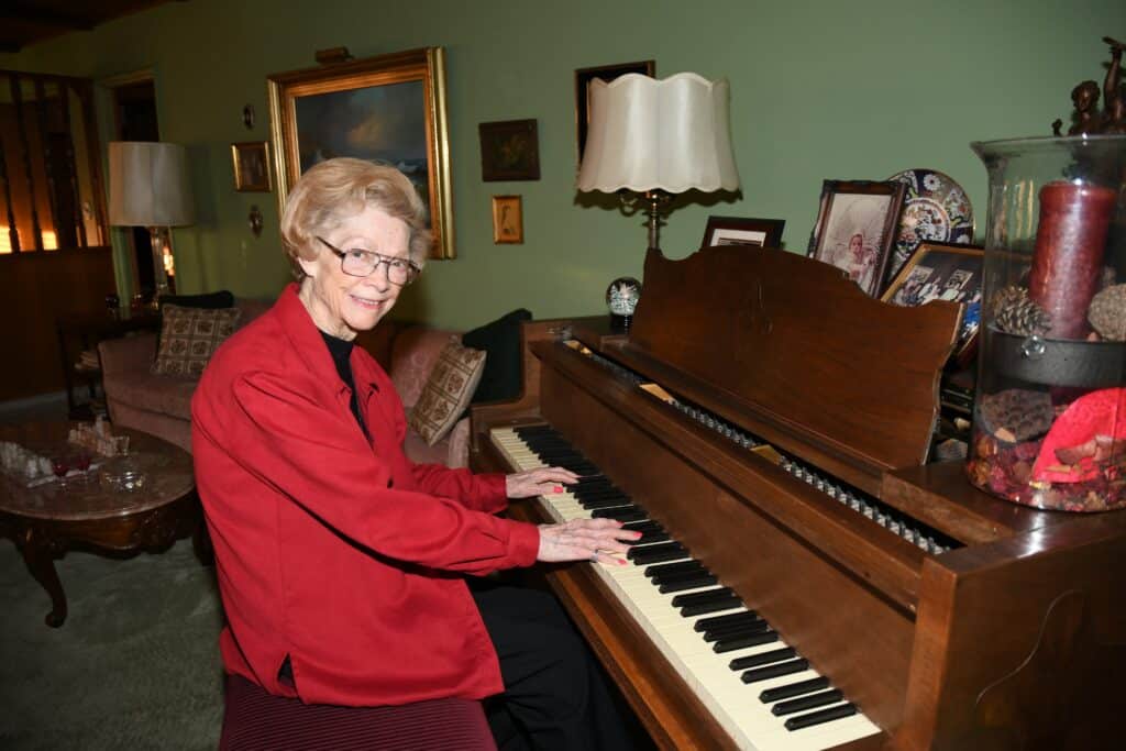 Madera woman playing piano in a cozy living room setting.