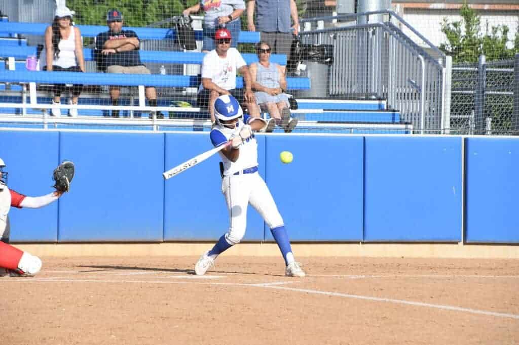 Photo - Madera’s Kailea Ricks rips a first inning double to score the first run of the game in Tuesday’s extra inning loss to Sanger. Ricks was responsible for all four Coyote runs. 
