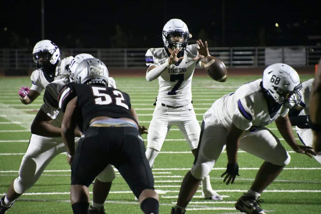 Madera high school football team during a game at night.