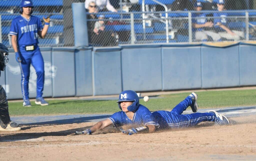 Player sliding into home plate during a baseball game.