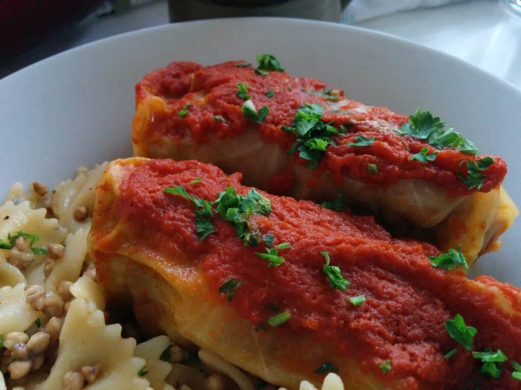 Chicken Parmesan with marinara sauce and melted cheese, served with pasta and fresh herbs.