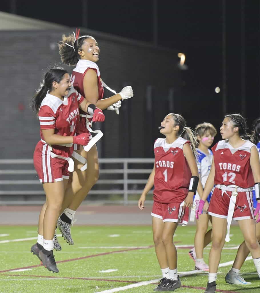 Young female soccer players celebrating victory on the field.