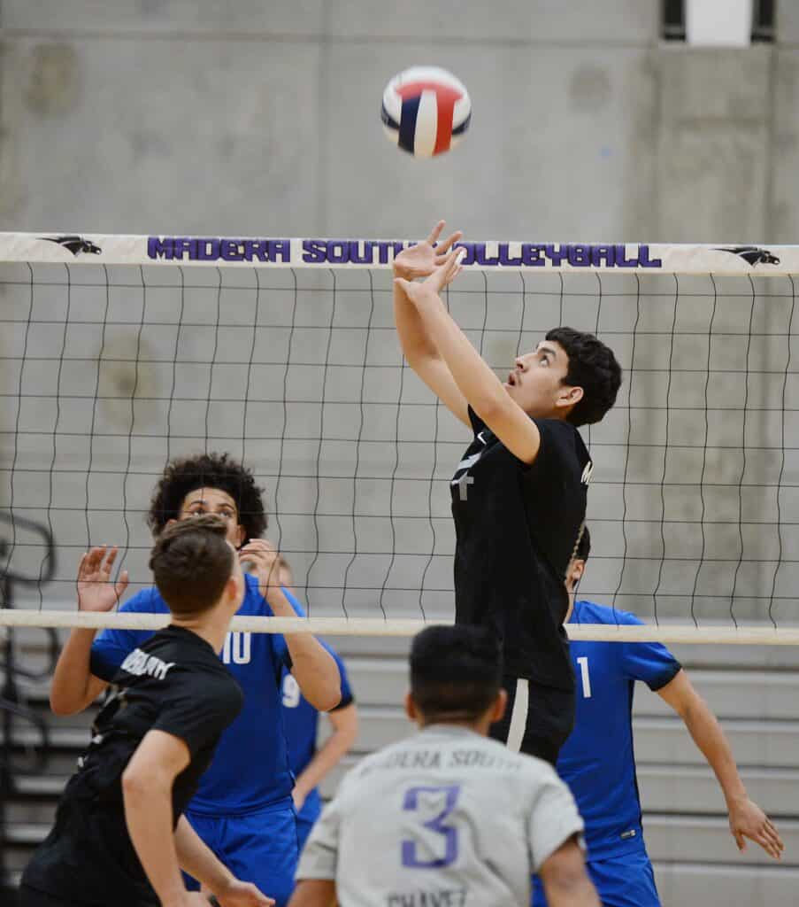 Volleyball player spiking ball at Madera South gym.