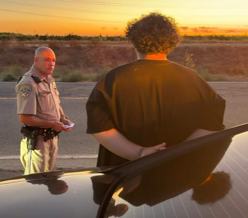Police officer talking to a driver during sunset.