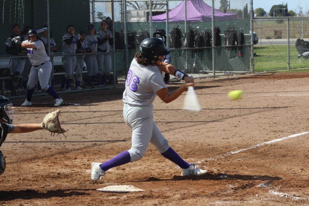 Softball player swinging at a pitch during a game in Madera.