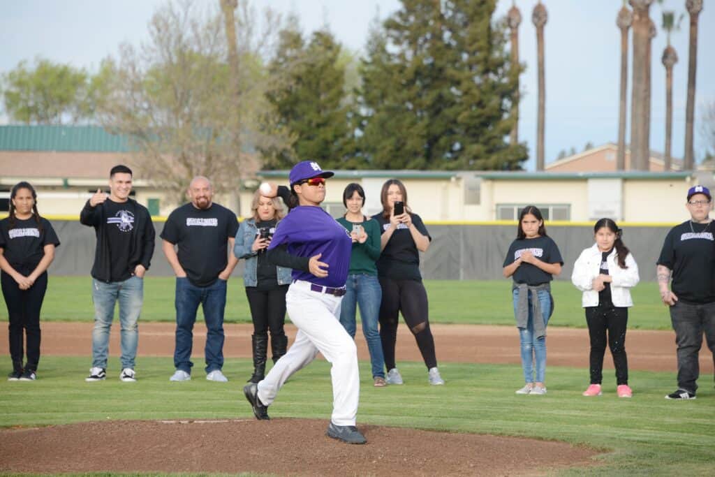 Madera baseball player practicing with team on the field.
