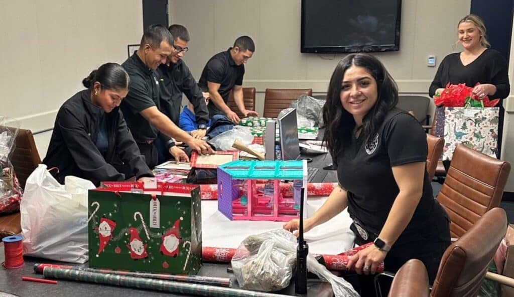 People wrapping presents with festive decorations and supplies.