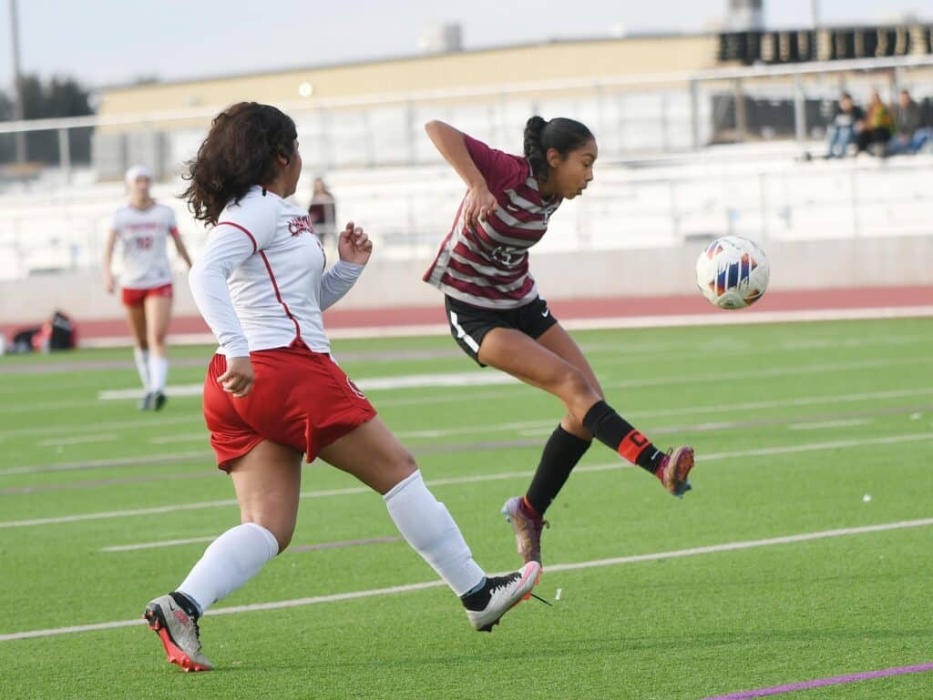 Female soccer players competing on the field during a match.