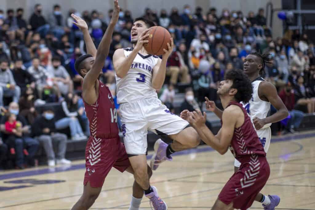 High school basketball game with players competing fiercely on the court.