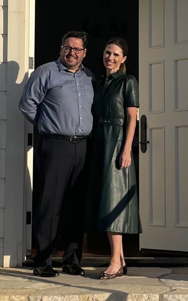 Man and woman standing at the entrance of a building.