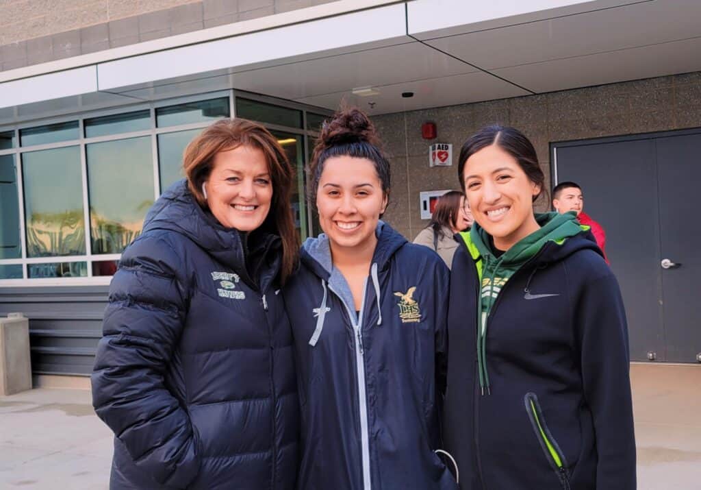 Young women smiling outdoors at a community event in Madera, California.