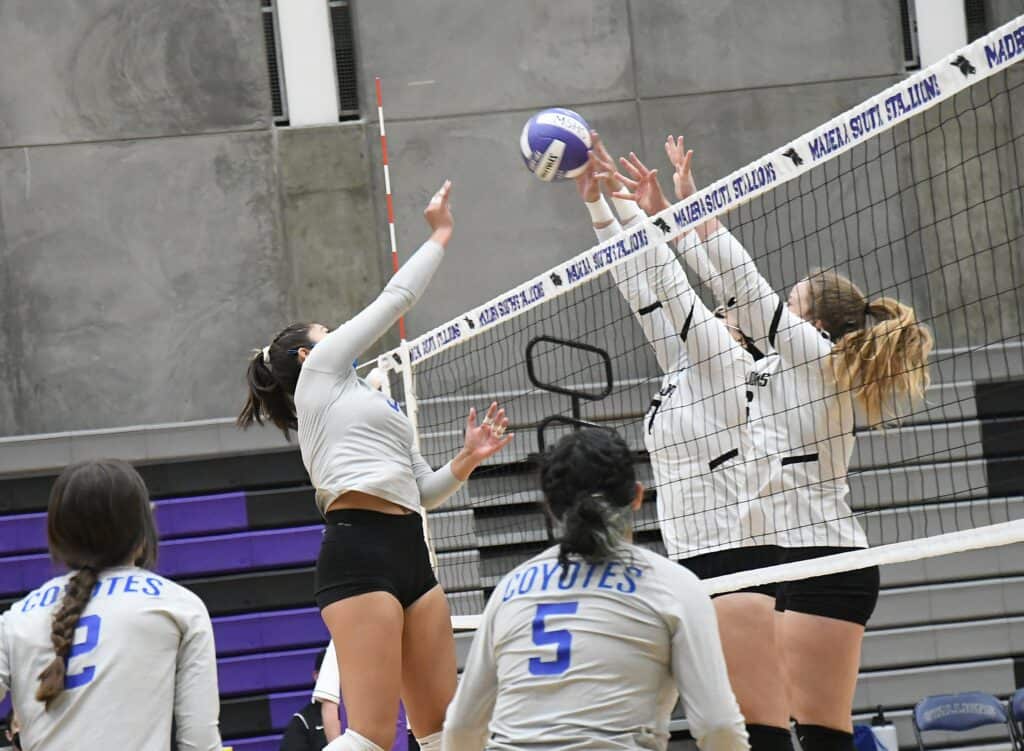 Girls playing volleyball at Madera high school gym.