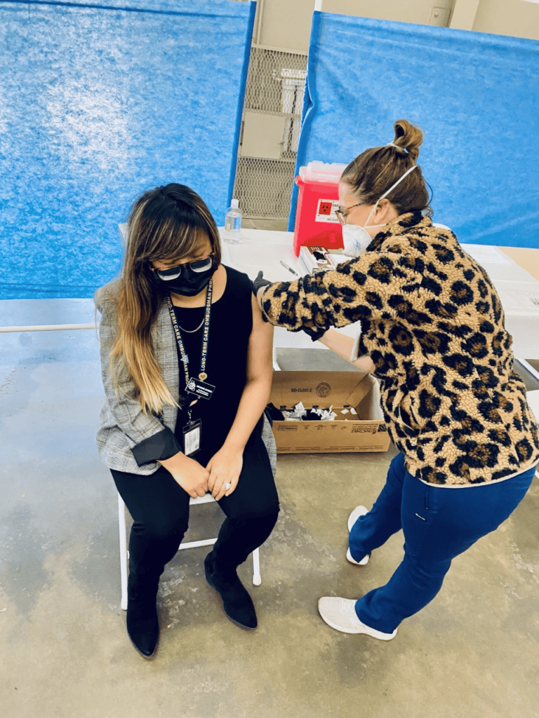 Woman receiving COVID-19 vaccine at Madera County health event.