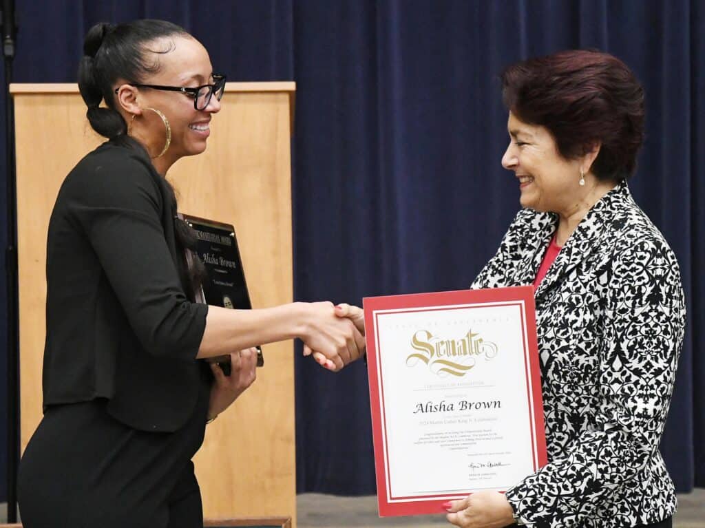 Two women shaking hands during award presentation in Madera.