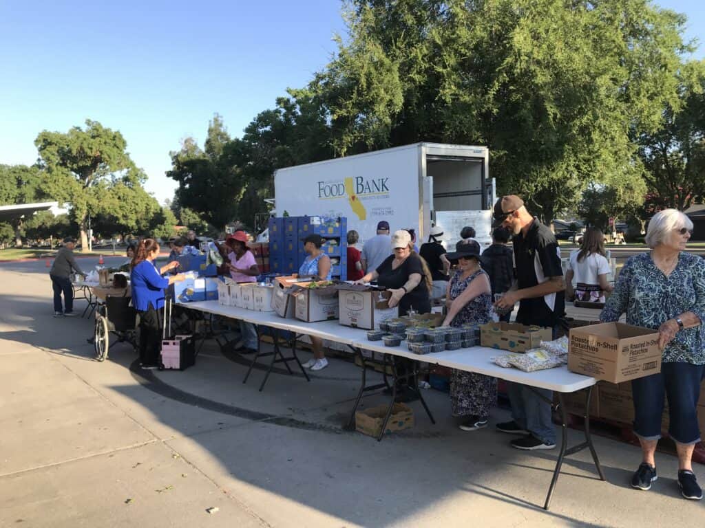 Community volunteers distribute food at a local food bank event.