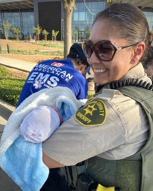 Baby being held by Madera County Sheriff officer.