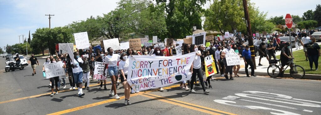 Protesters holding signs during a community demonstration in Madera.