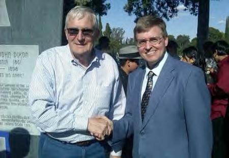 Two men shaking hands at community event.