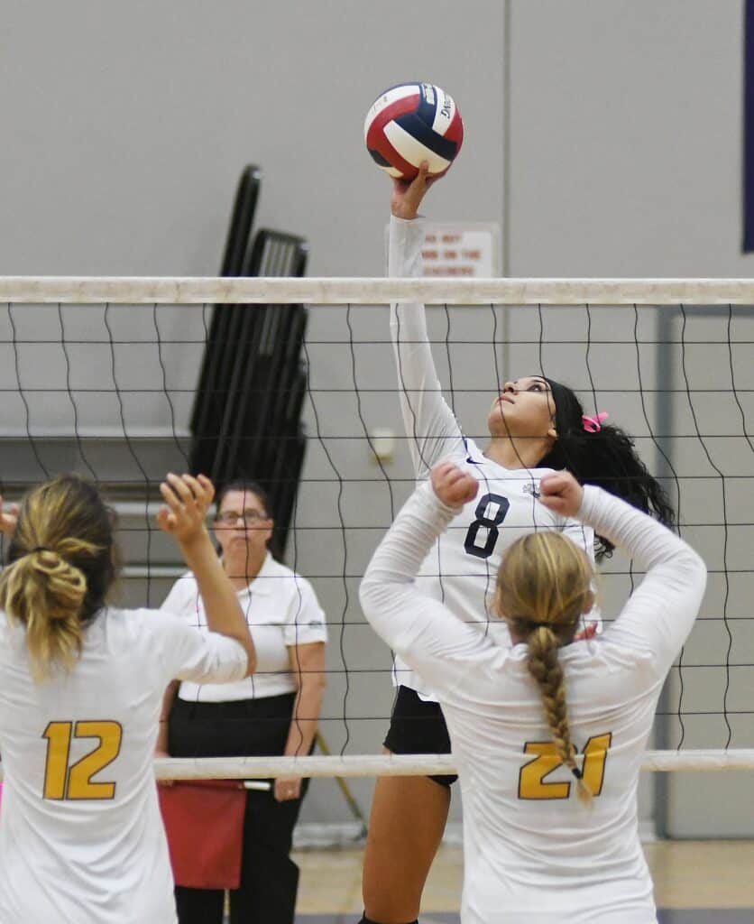 Volleyball player spiking the ball during a match at Madera Tribune event.