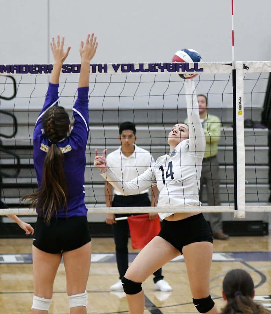 Madera South volleyball player spiking the ball over the net.