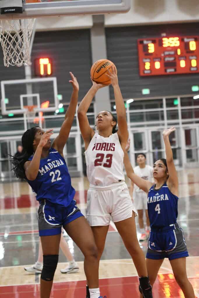 Female basketball player shooting during a game at Madera sports arena.