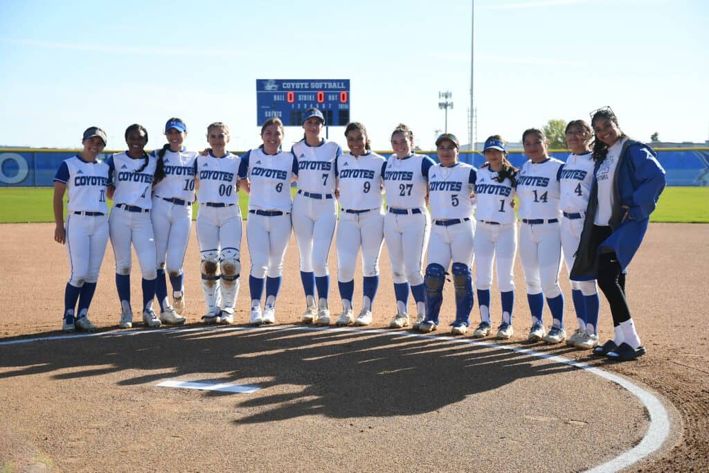 Madera softball team standing on the field before a game.