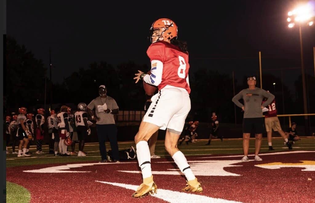 Football player in action during a night game at Madera High School.