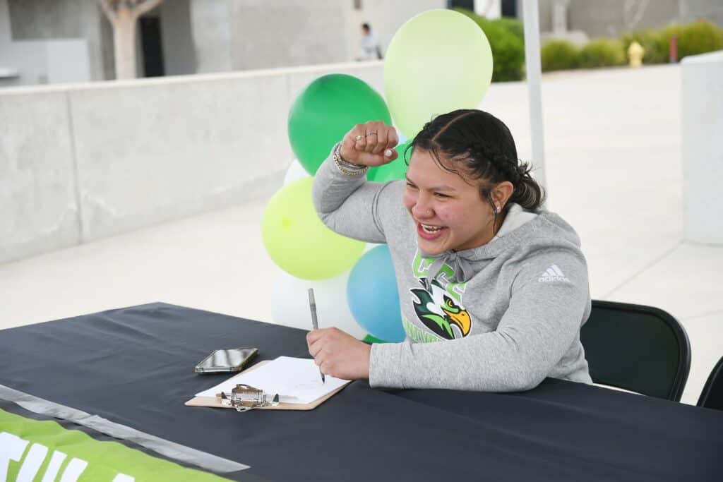 Young woman celebrating at community event with balloons.