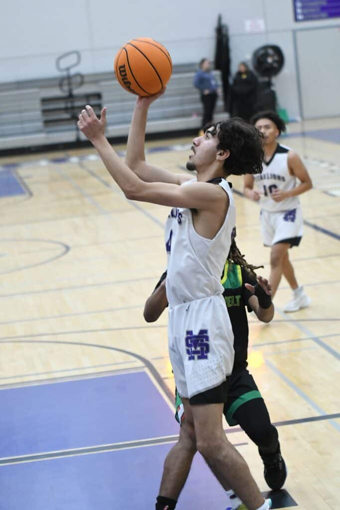 Young female basketball player shooting during a game in Madera gym.