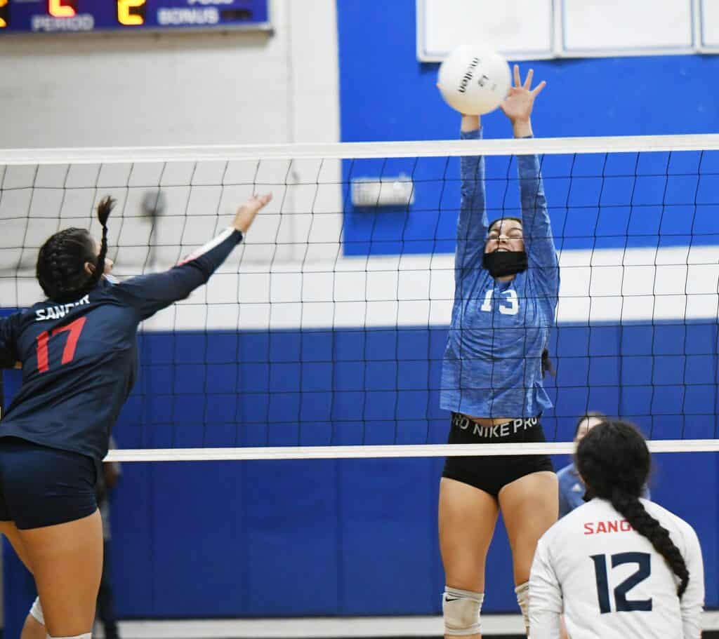 Volleyball players in action during a match at Madera gym.