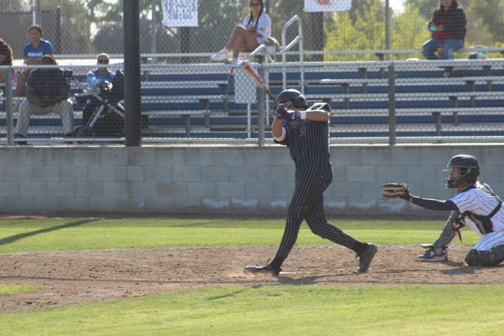 Player swings at a pitch during a high school baseball game in Madera.