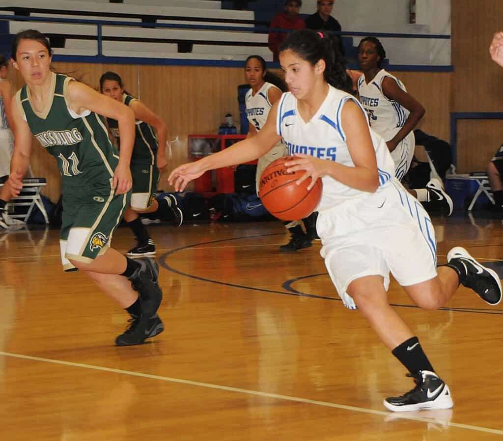 Young female basketball player dribbling during a game.