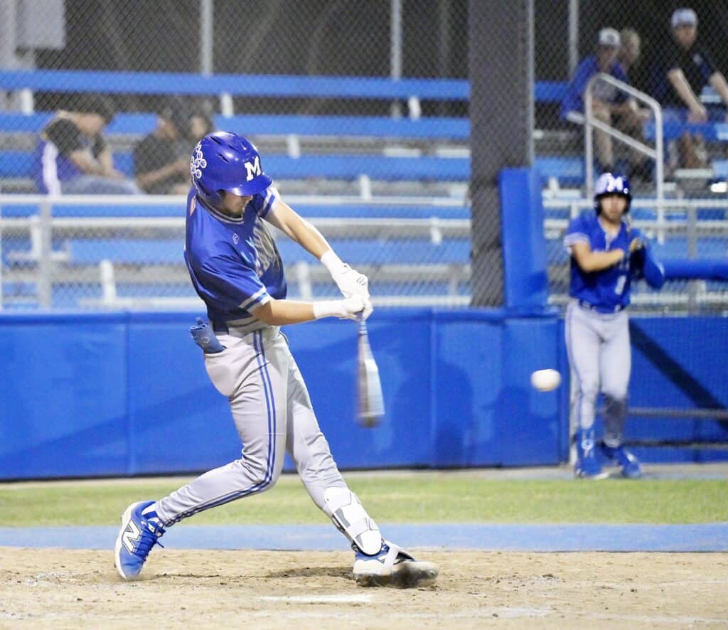 Young baseball player swinging at pitch during game in Madera.