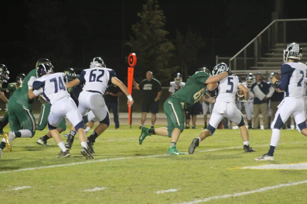 Madera high school football players in action during a night game.