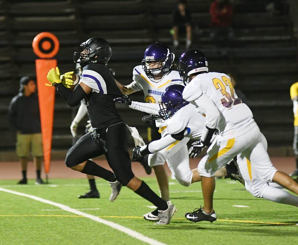 Madera football player running with the ball during a game.