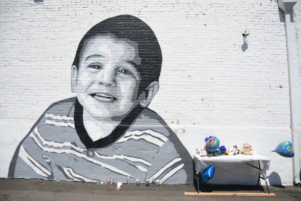 Mural of a smiling boy on a brick wall in Madera, California.