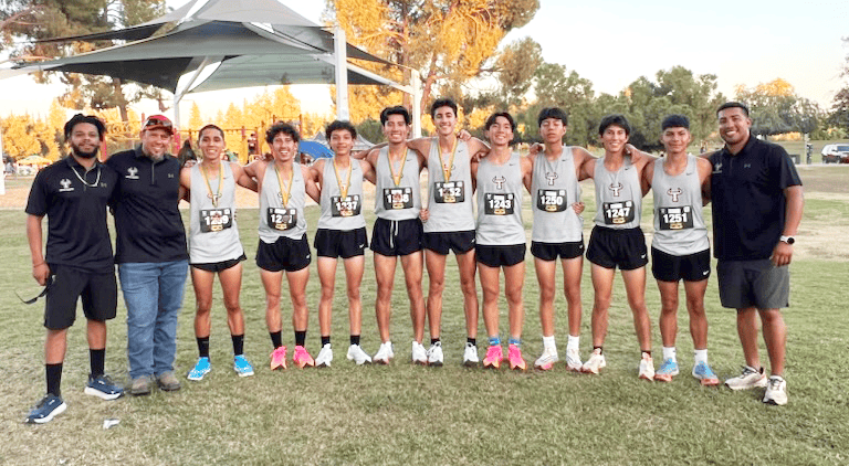 Madera high school track team with medals after race victory.