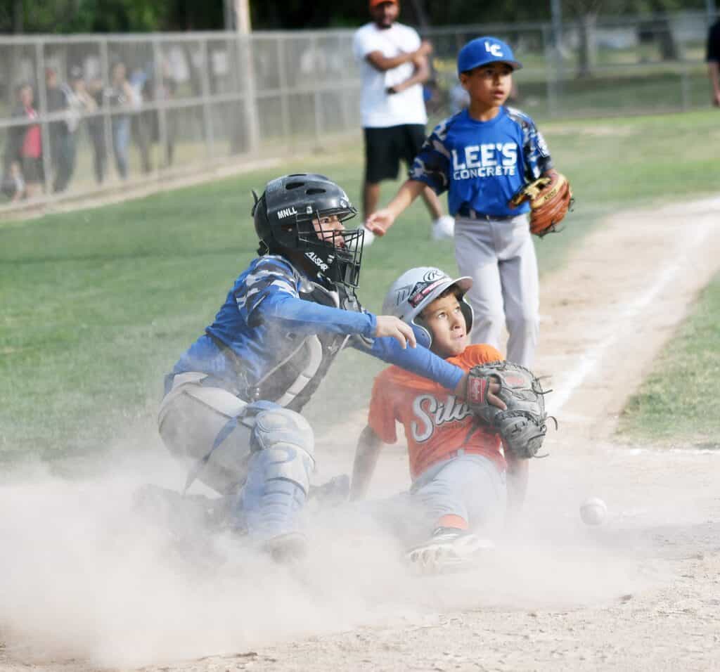 Photo - Lee’s Concrete catcher Justin Ornelas puts the tag on Silva’s Construction’s Benjamin Jackson sliding into home plate, but it was just a little late as Jackson was ruled safe.