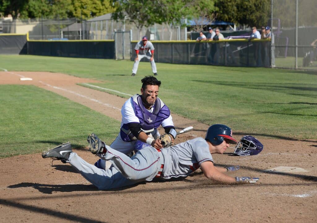 Baseball player sliding into home plate during game.