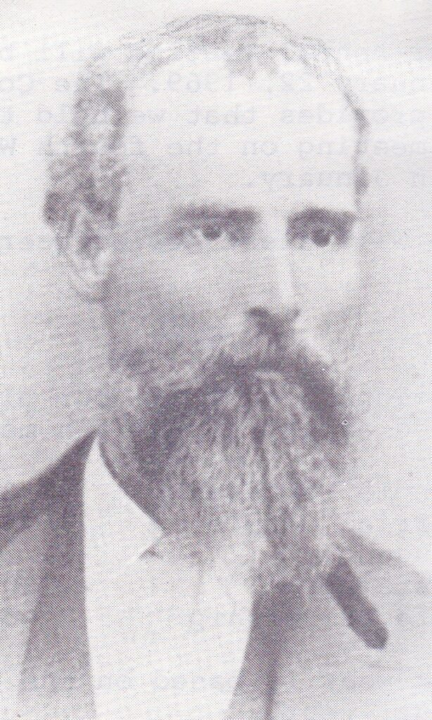 Black and white portrait of a man with a beard and mustache, vintage style.