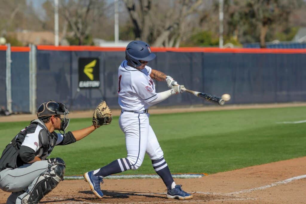 Young baseball player swinging at a pitch during a youth game.