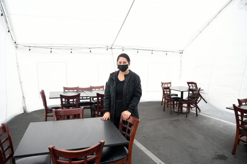 Indoor dining setup with a woman wearing a mask at a restaurant in Madera.