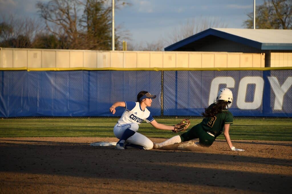 Softball player sliding into base during a game at Madera High School.