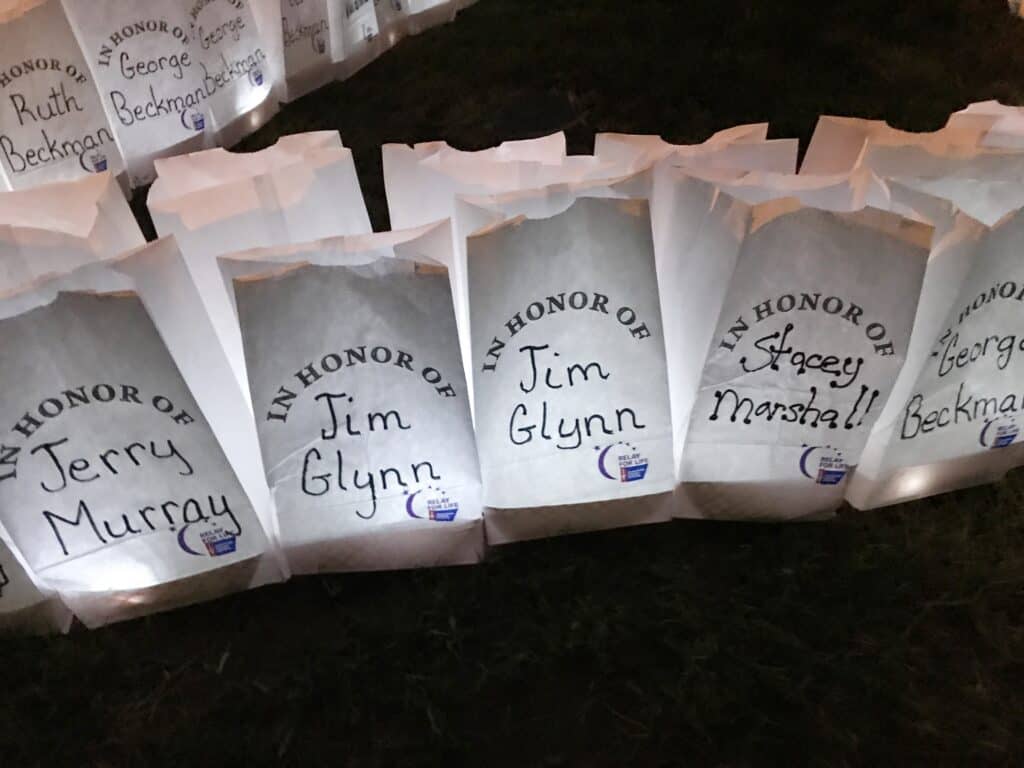 Memorial paper bags honoring George Beckman, Jim Glynn, and Stacey Marshall at tribute event.