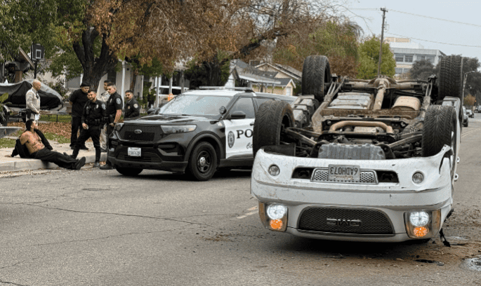 Photo of A vehicle sits upside-down after a crash on H and 2nd streets December 19. The driver (sitting on the curb) was found to be under the influence, and placed under arrest.