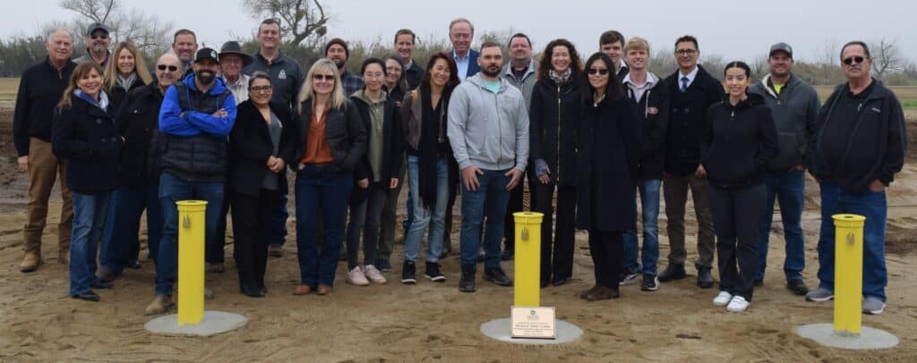 Photo of Members from the Madera Irrigation District stand with members from Stanford University in front of a well field named after Stanford professor Richard Luthy. The MID and Stanford are partnering to research groundwater recharge.