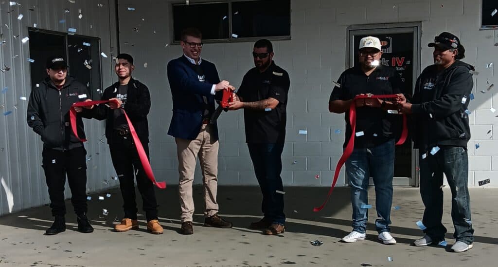 Photo of Mark IV Metal Products President Andrew Segal, left, cuts the ceremonial ribbon with Chowchilla facility General Manager Pedro Orozco as confetti flies to mark the official grand opening of the facility on Friday.