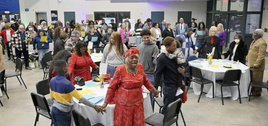 Photo of Community members join hands to sing “We Shall Overcome” at the conclusion of Sunday’s Martin Luther King, Jr. Celebration.