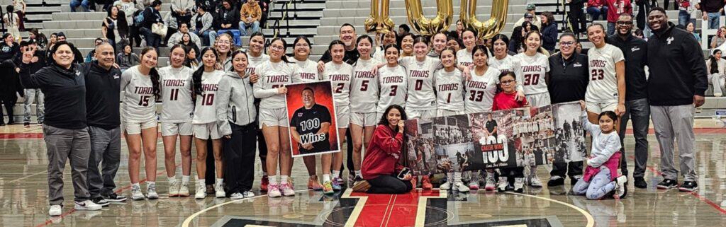 Photo of The Matilda Torres varsity basketball team, coaches and supporters gather at center court to celebrate head coach Jose Villalobos’ 100th career coaching victory, as well as a berth in the Div. IV Central Section championship game, after defeating Mendota on Friday. 