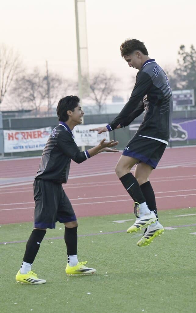 Photo of Madera South’s Jimy Figueroa (right) congratulates Manuel Martinez after Martinez scored the Stallions’ lone goal in Tuesday’s loss to the Sanger Apaches. Figueroa initially started the scoring chance, and fed to Daniel Rocha, who got the assist.